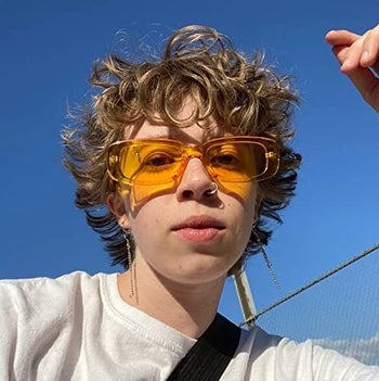 model wearing yellow neon rectangular frame glasses