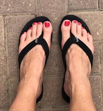 reviewer wearing black thick-ish strap flip-flops