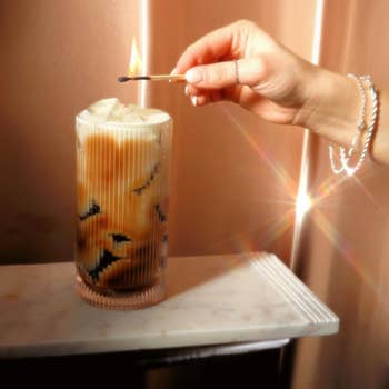 Hand lighting a candle successful  a glass, giving a cozy ambiance suitable for location  decor