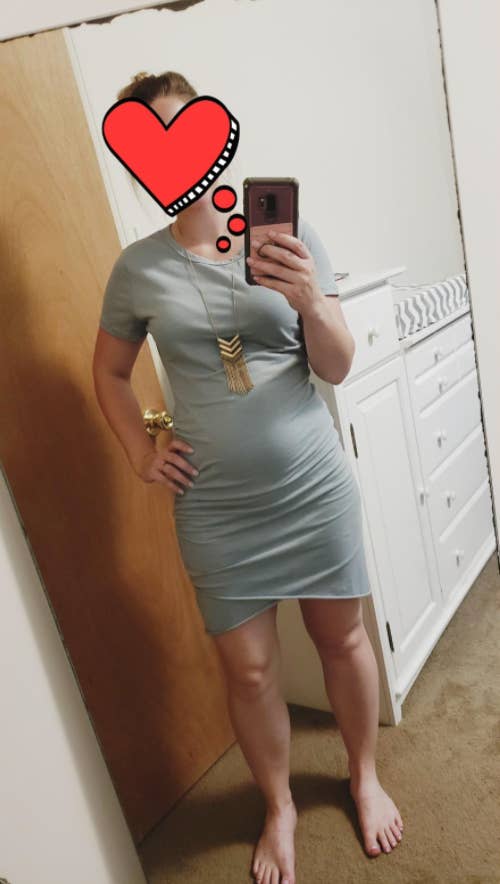 reviewer wearing the dress with a tulip hem with a baby bump visible