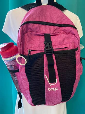 reviewer photo of a pink daypack with a water bottle in its side pocket