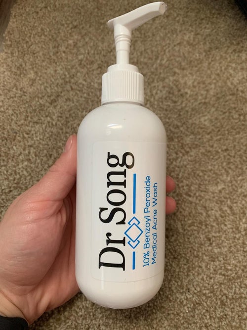 reviewer holding up bottle of body wash