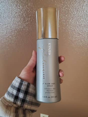 a reviewer holding up the spray