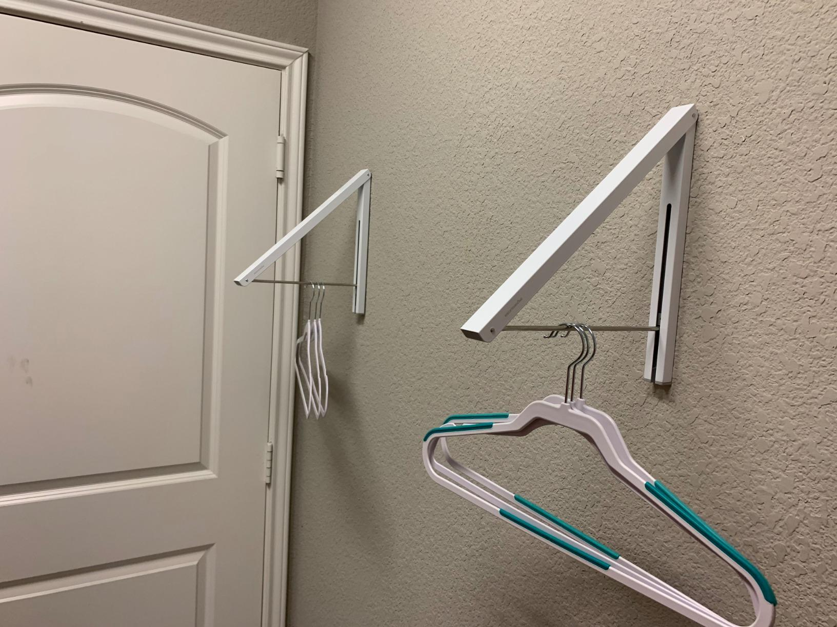 reviewer photo of the arms of the rack pulled down and several empty hangers hanging from them