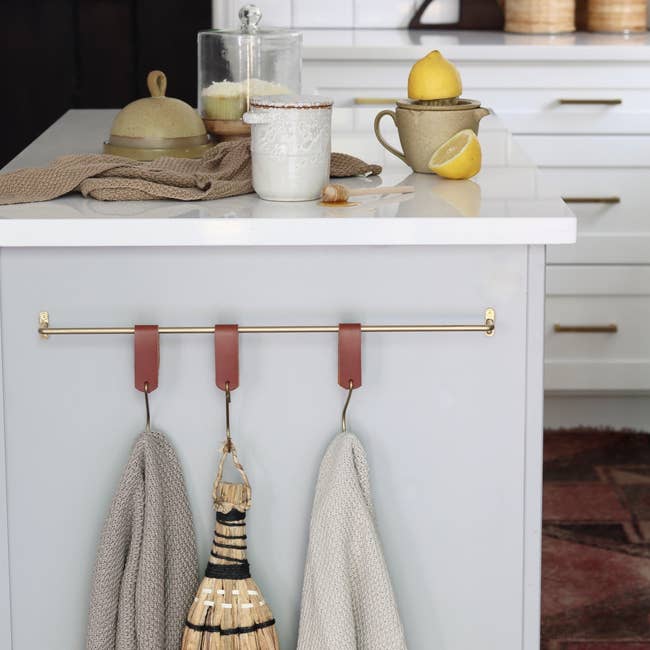 the brass hanging rack on the side of a kitchen island