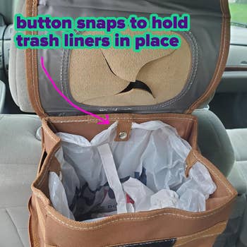 Car trash can with lid open, showing button snaps to hold trash liners in place