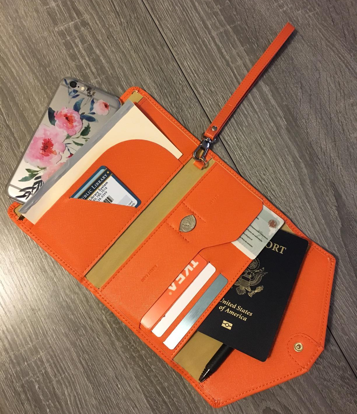 reviewer photo of the wallet open, showing all the different pockets for passport, cards, money, phone, and more