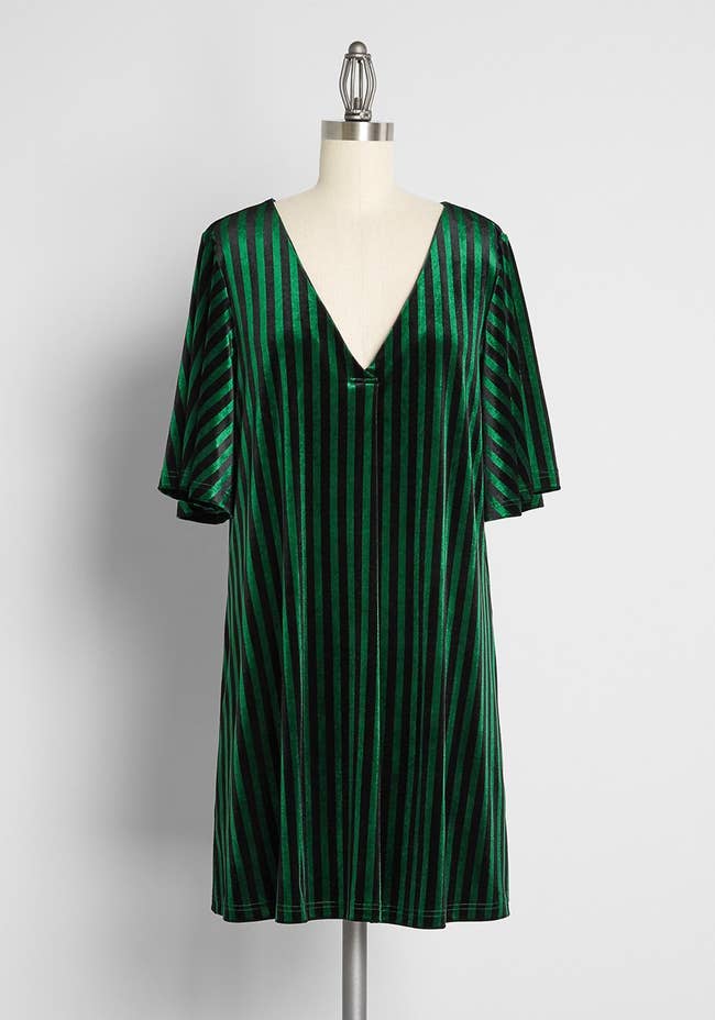 a green dress with flutter sleeves and vertical green and black stripes