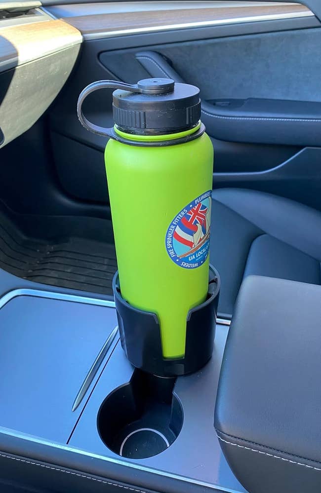Green water bottle with logo in car cup holder