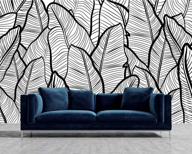 Black and white leaf wall art behind blue couch