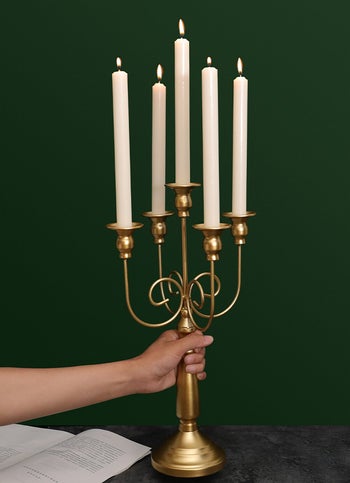 a hand holding the candelabra