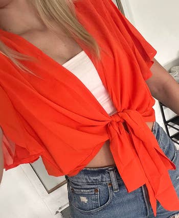 Reviewer wearing a front-tie crop top in red 