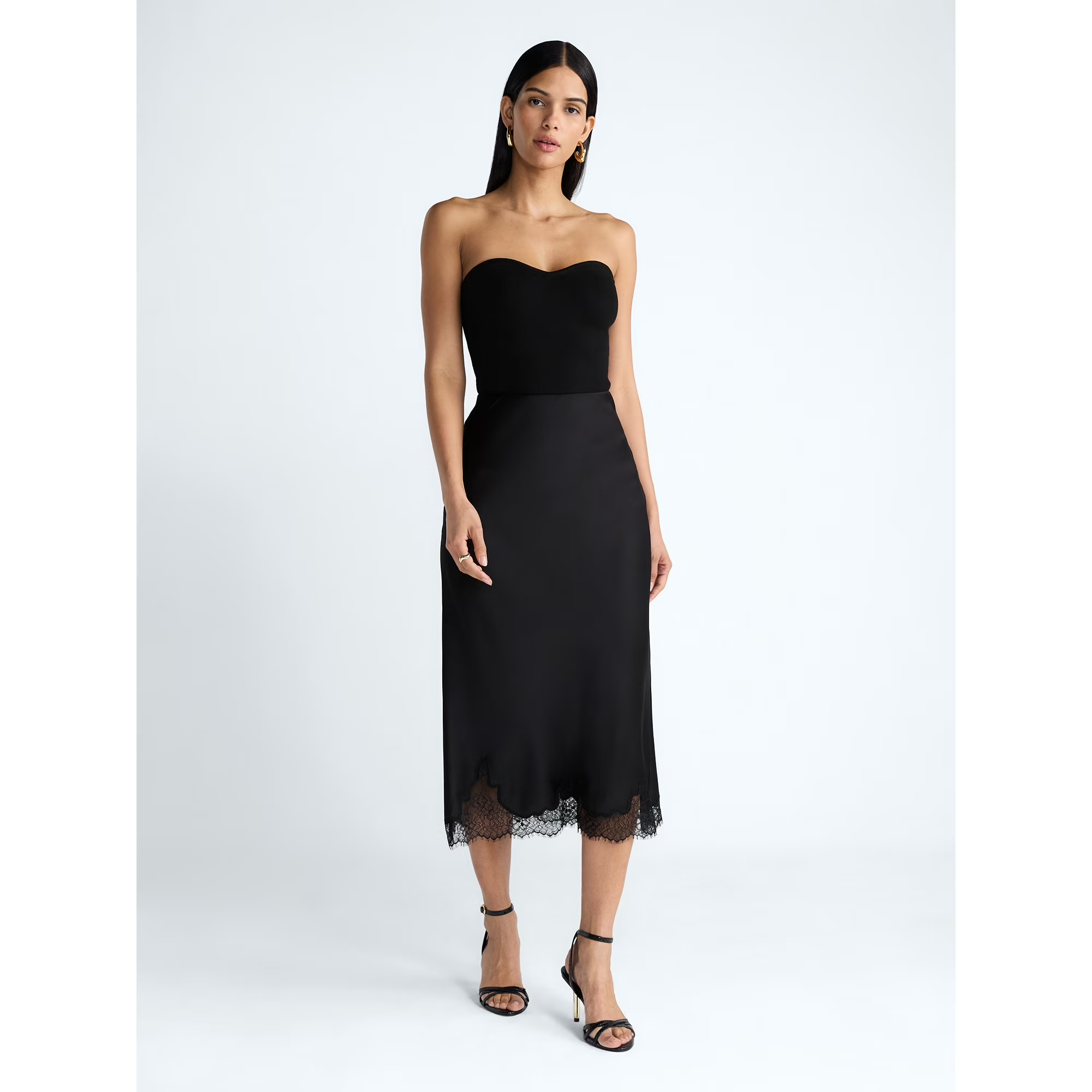 Person successful  chic, strapless achromatic  midi formal  with lace hem, wearing strappy heels. Fashion-forward benignant   for a buying  article