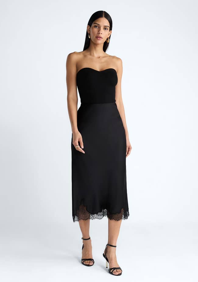 Person successful chic, strapless achromatic midi formal with lace hem, wearing strappy heels. Fashion-forward benignant for a buying article