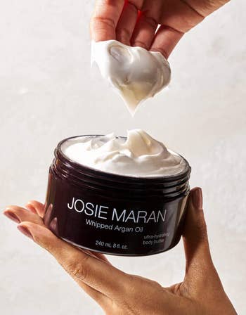 a hand dipped in the thick creamy body butter