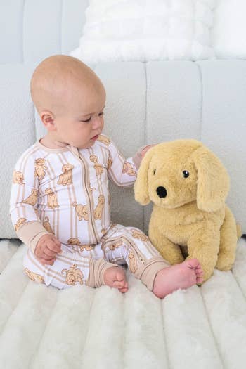Baby successful  puppy-print pajamas sits connected  a brushed  aboveground  beside a plush canine  toy