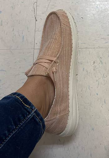 a reviewer wearing the shoes in sparkly rose gold 