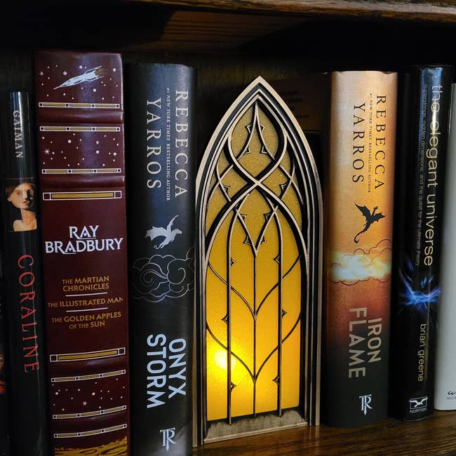 book nook with yellowish  window, golden  and achromatic  frame, and airy  shining down  it lasting  connected  a support  holding phantasy  books