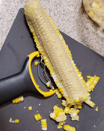 reviewer photo of an ear of corn that's had half of its kernels stripped away using the peeler