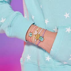 model wearing four bracelets with charms on their hand