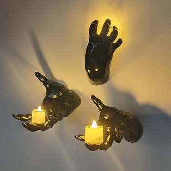 The three wall-mounted hands being used as candle holders