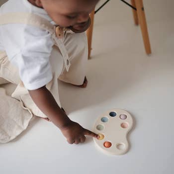 child playing with rubber paint pallet bubble toy