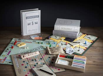 the monopoly, scrabble, and clue game boards next to their book-like packaging