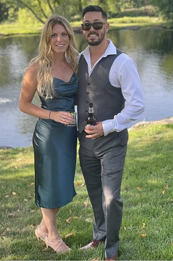 A reviewer successful  a sleeveless, knee-length greenish  formal  