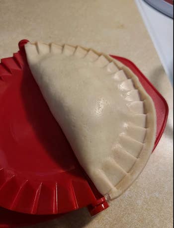 An empanada pressed from a red mold 