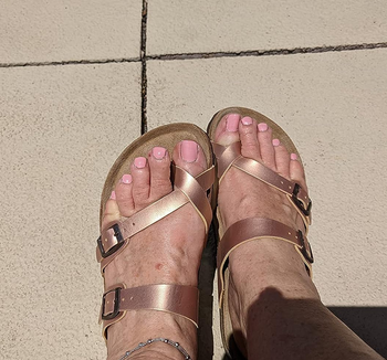 a reviewer wearing the shoes in rose gold tone