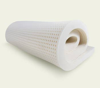a rolled up latex mattress topper