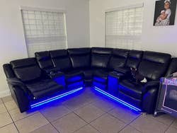 reviewer photo of black faux leather reclining sectional with blue LED strip