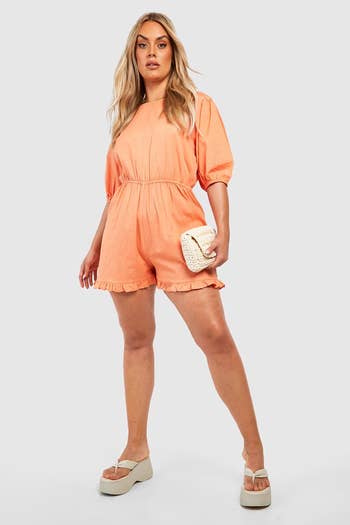 model wearing the romper in coral