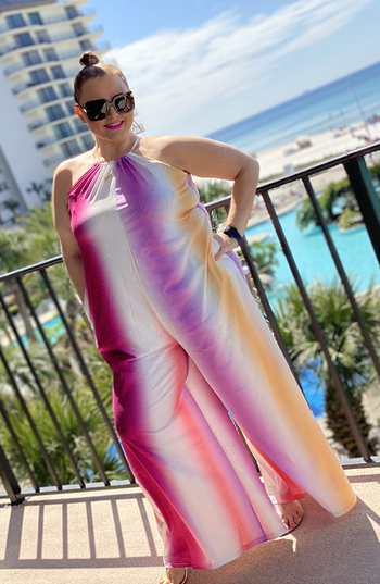 a reviewer wearing the jumpsuit in pink and orange