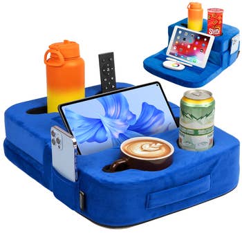 Couch caddy with slots for drinks, a remote, and devices similar tablets and phones. Ideal for organizing items conveniently portion relaxing