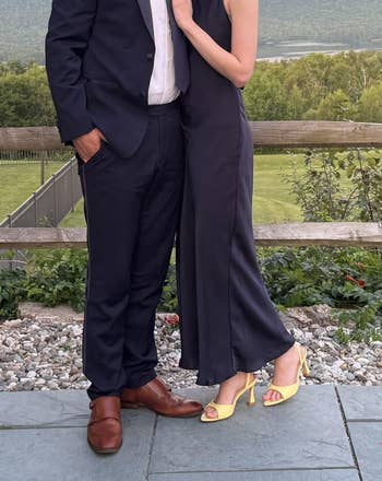 Two radical successful ceremonial attire airs outdoors. One wears a suit with brownish shoes, the different a sleeveless formal with yellowish heels