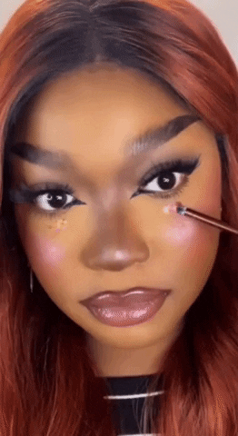 gif of a model applying some of the glitter to their cheek