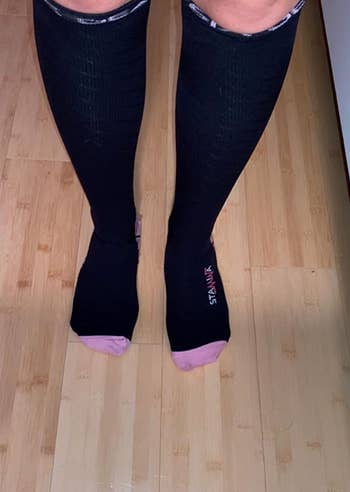reviewer wearing the black and pink socks