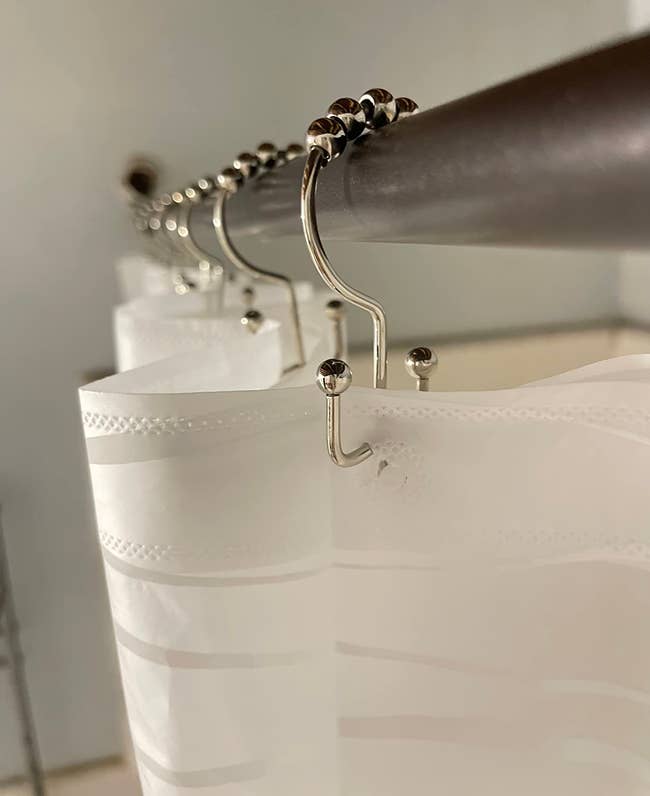 Close-up of a ablution curtain hung connected metallic hooks, applicable for bath decor and accessories