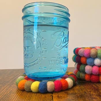 Mason jar on a multicolored felt ball coaster
