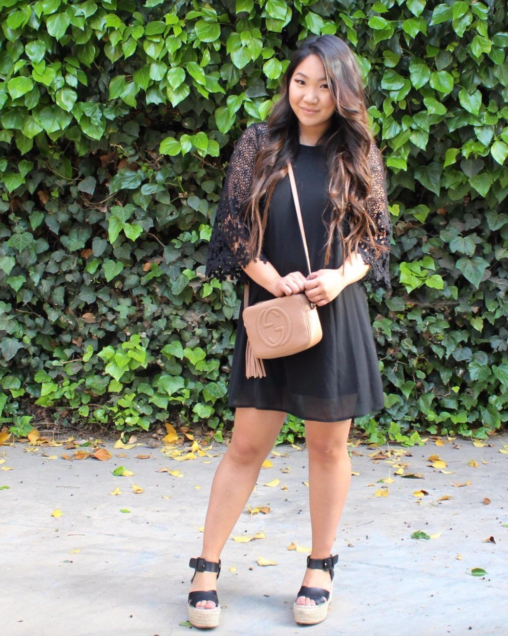 reviewer in a black lace sleeve midi dress