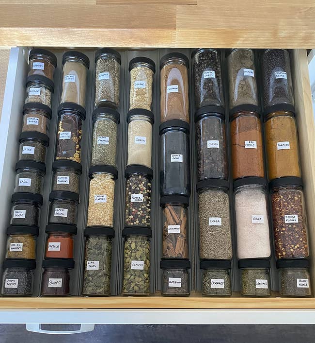 A reviewer's spice bottles neatly lined in a drawer