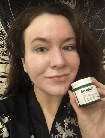 BuzzFeed editor holding the product with it applied to their face 