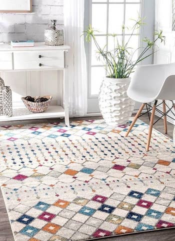 reviewer photo of the multicolored rug near a chair and a table