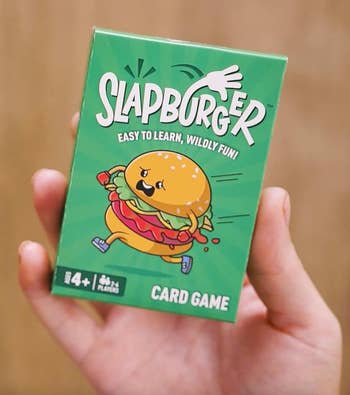 A hand holds a green box of the