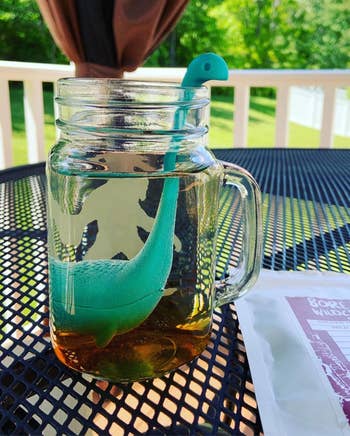 the teal nessie tea infuser in a mug of water