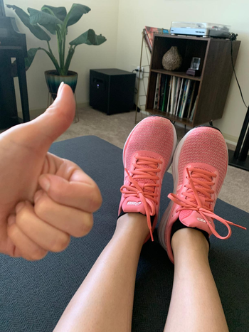 reviewer shows thumbs up while wearing same ASICS in an all pink color before running