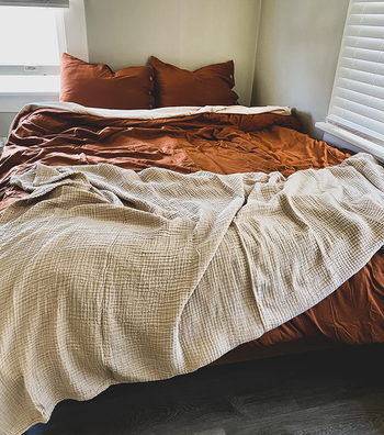 the muslin throw tossed across the end of a bed