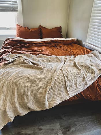 the muslin throw tossed across the end of a bed