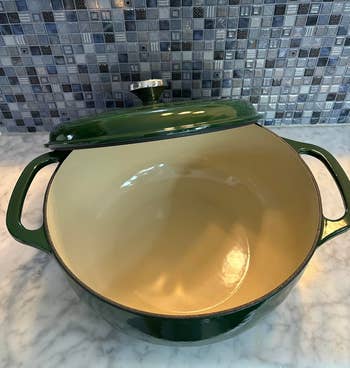 Same green dutch oven opened to show ceramic interior